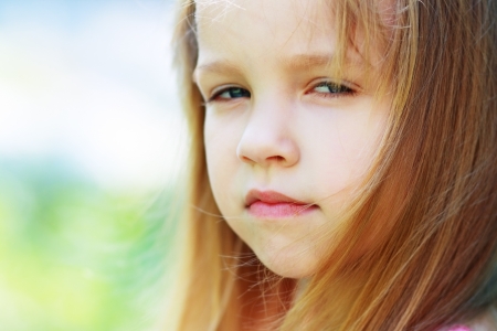 Closeup portrait of little girl outside with a questioning expressionの写真素材
