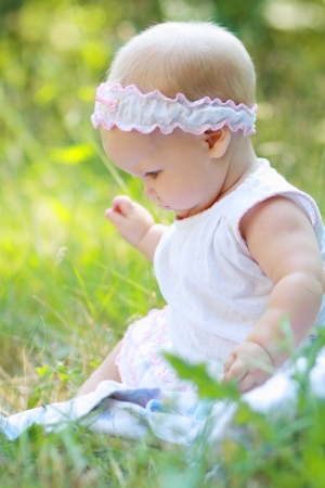 Portrait of happy smiley baby girl on natural background in summerの写真素材