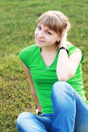 Portrait of young beautiful brunette woman yellow bright dress, laying on grass at summer green park. の写真素材