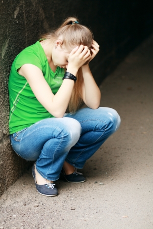Outdoor portrait of a sad teenage girl looking thoughtful about troublesの写真素材