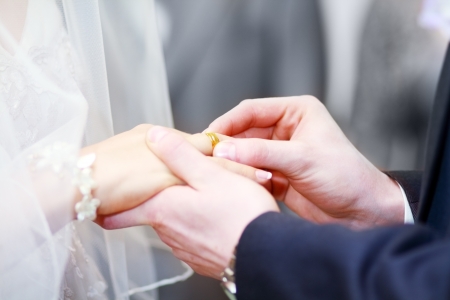 groom put on wedding ring to bride's handの写真素材