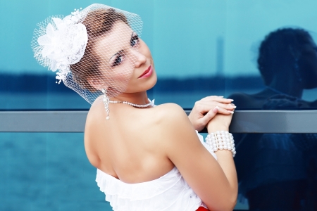 Beautiful young bride has veil over her head and face.の写真素材