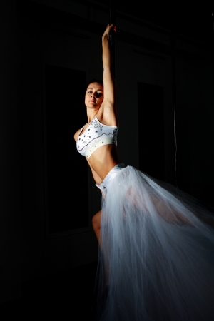 Young slim pole dance woman in dance studioの写真素材