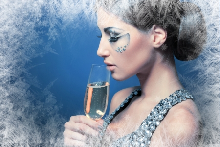 beautiful young woman with creative face art make up drinking Champagneの写真素材
