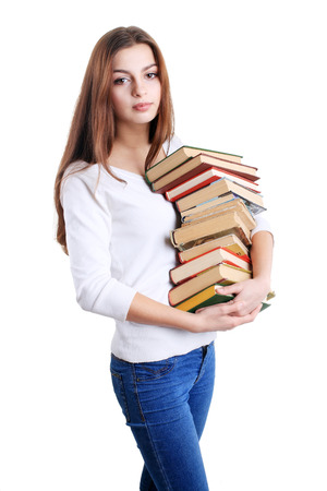 latin teenage girl standing and hugging a books pile の写真素材