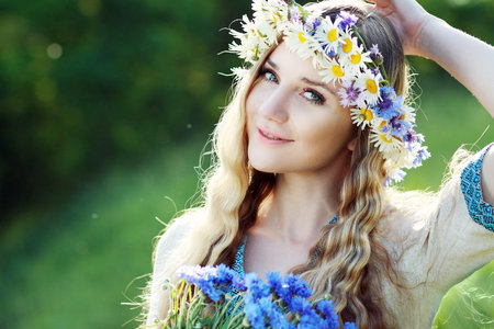 Beautiful ukrainian woman with flower wreath in fresh summer morning. の写真素材