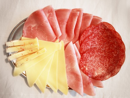 plate of raclette cheese and ham meetの写真素材