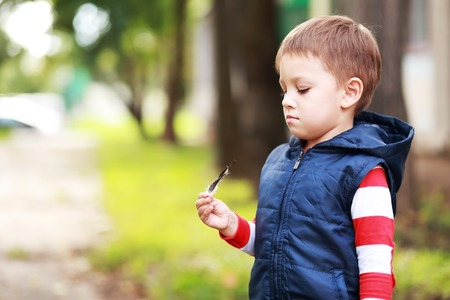 stylish baby boy having fun outside in the park. Cute happy boy child outdoorsの写真素材
