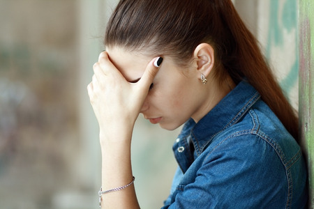Outdoor portrait of a sad teenage girl looking thoughtful about troublesの写真素材