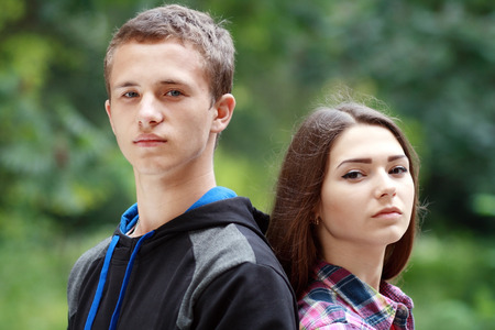 teenage girl and boy portrait standing outdoor in green parkの写真素材