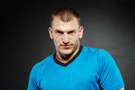 strong handsome man with serious expression on dark backgroundの写真素材