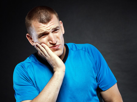 Toothache - suffering young man with teeth problemsの写真素材