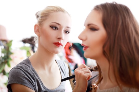 Backstage scene: Professional Make-up artist doing glamour model makeup at workの写真素材