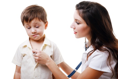 Smiling doctor auscultating a child with a stethoscopeの写真素材