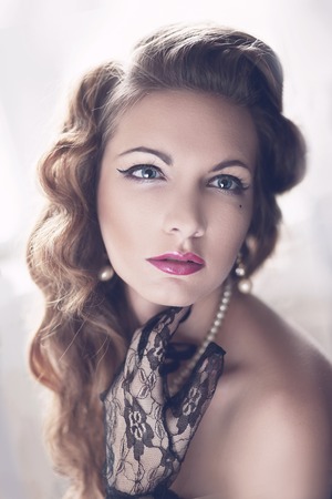 Fashion Brunette Model Portrait. Jewelry and Hairstyle. Elegant lady Isolated on black background.の写真素材