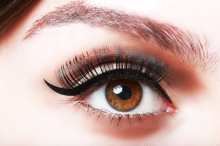 extreme closeup of brown beautiful womanish eye with glamorous makeup and falce eyelashes macroの写真素材