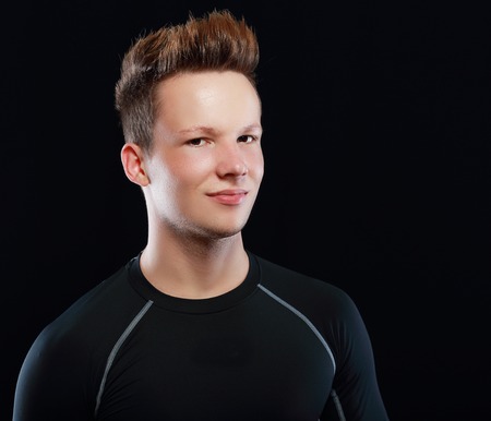 Young male model over black background with a black t-shirtの写真素材