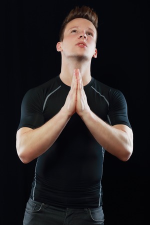 Young man praying in the darkの写真素材