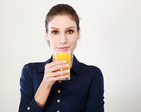 Young woman close up portrait drink juice. Female model happy smile.の写真素材