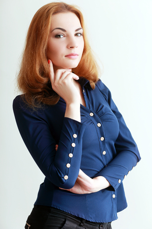 beautiful red haired young business woman thinkingの写真素材