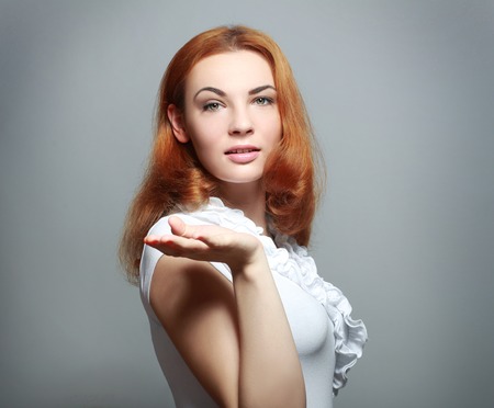 Happy , excited young woman presenting copy space on her palm, isolated on grey backgroundの写真素材