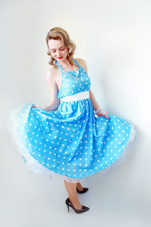 A vintage photo of a glamour pin-up girl wearing a retro polka-dot dress.