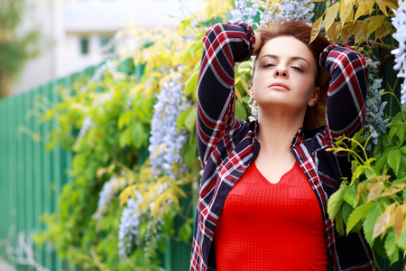 Beautiful red haired woman wearing jeans and shirtの写真素材