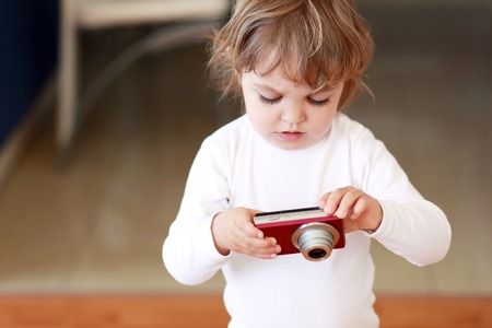 Little girl with compact photo cameraの写真素材