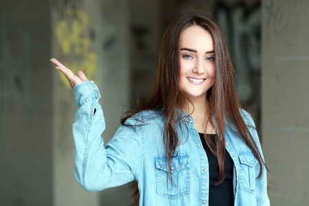 young teen woman show hand to copyspace outdoor portraitの写真素材