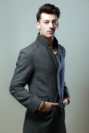 Young handsome man in a coat - studio male portrait Toned image fashionの写真素材