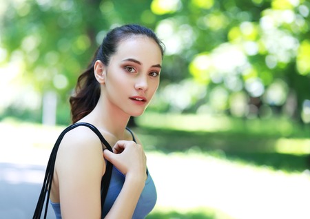 Beautiful young woman exercising outdoors and smilingの写真素材