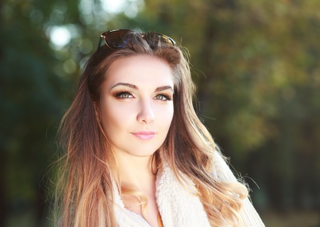 beautiful woman portrait outdoor with early autumn park backgroundの写真素材