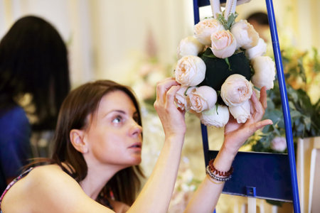 florist making bride bouquet, shallow depth, selective focuse on the flowers