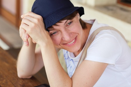 german woman tourist sitting at the table and smilingの写真素材