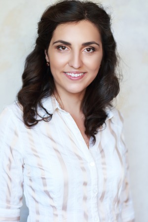 beautiful brunette woman in corporate portrait sitting and smilingの写真素材