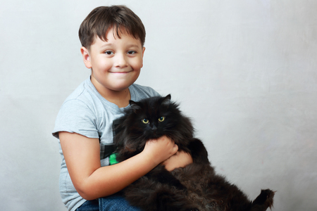 7 years boy hold a black furry catの写真素材