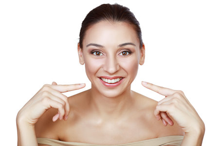Close up portrait of woman smiling pointing on her teeth isolated on white background