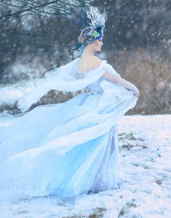 Beautiful woman as Snow Queen in winter snowy forestの写真素材