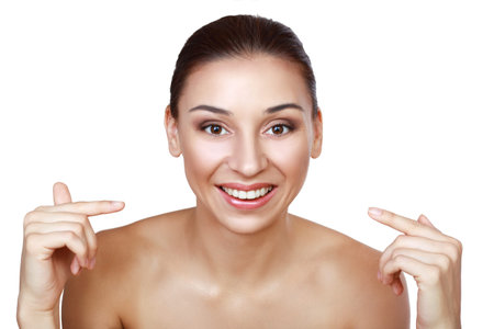Close up portrait of woman smiling pointing on her teeth isolated on white background
