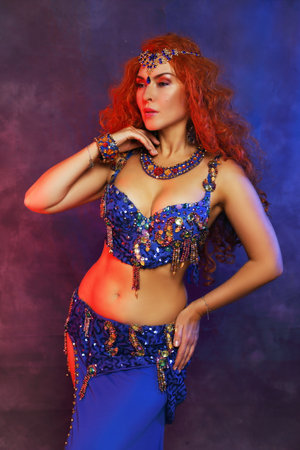 Bellydancer in action blue bra costume red hair beautiful performerの写真素材