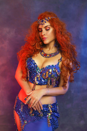 Bellydancer in action blue bra costume red hair beautiful performerの写真素材