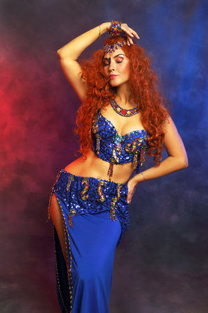 Bellydancer in action blue bra costume red hair beautiful performerの写真素材