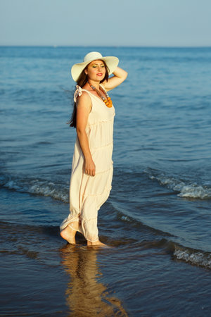 woman in sunhat standing in the water of Adriatic seaの写真素材