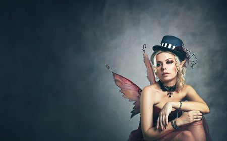 red elf fairy wearing fansy hat over blue fantasy backgroundの写真素材