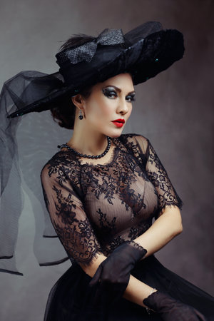 Femme fatale woman in black fashionable hat and lace dressの写真素材