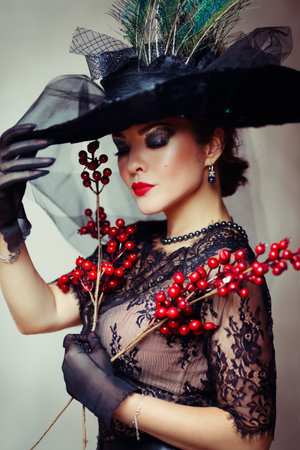 Femme fatale woman in black fashionable hat and lace dressの写真素材