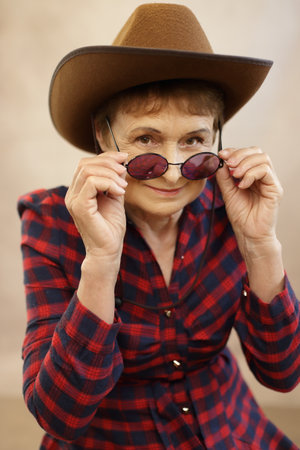 pretty woman wearing cowboy hat cowgirl in her 70sの写真素材
