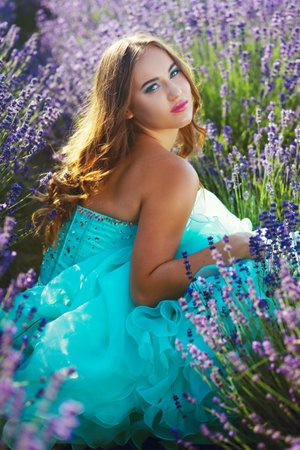 beautiful youn model in turquoise  gown relaxing on lavender fieldの写真素材