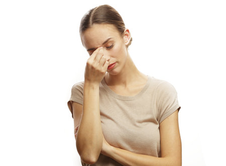 sressed depressed woman touching her forehead and noseの写真素材