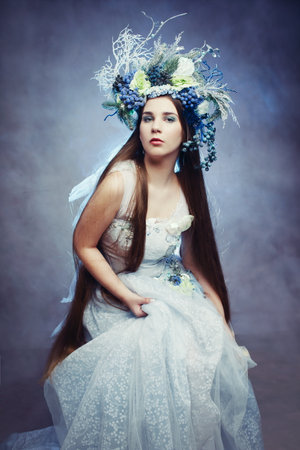 Snow queen or winter fairy in floral frost crown light blue dressの写真素材